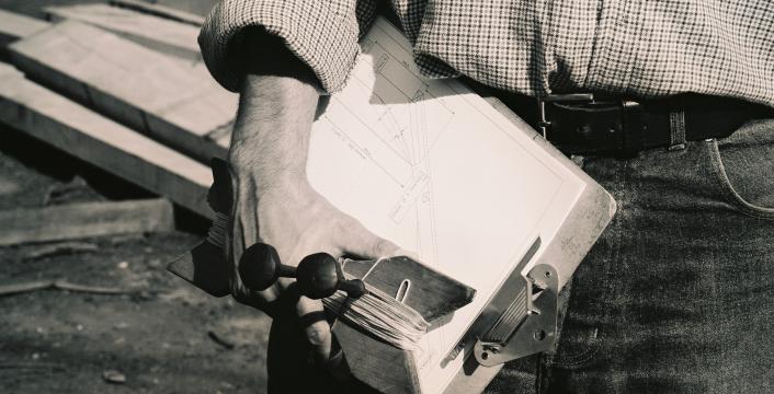 A black and white photo of a man holding a clipboard.