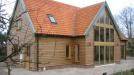 Oak framed house with direct glazing and oak weatherboarding.