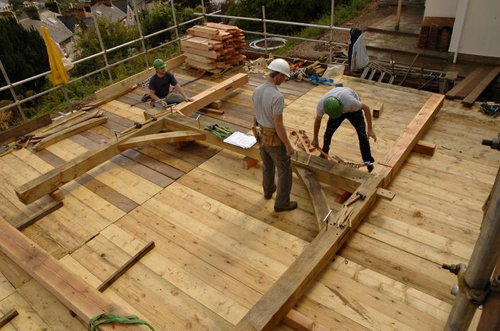 A Douglas fir cross frame being assembled on a scaffolding deck.