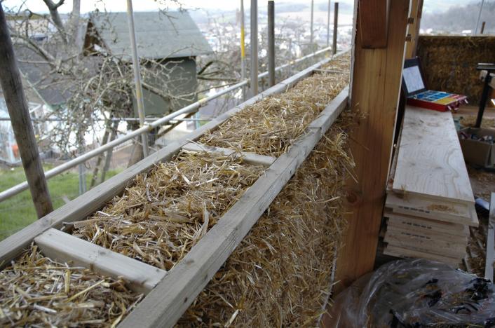 A straw bale wall being built.