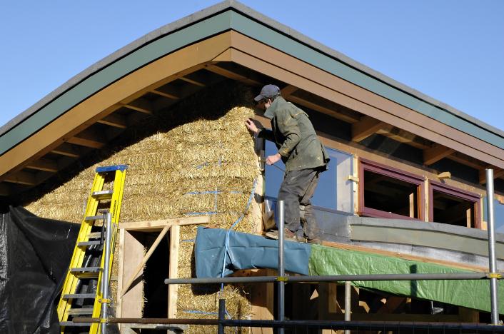 The outside of a straw bale house, during its construction.