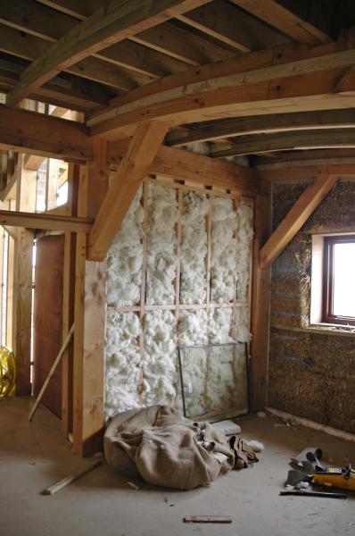The interior of a Douglas fir framed house with a sheeps wool wall being built.