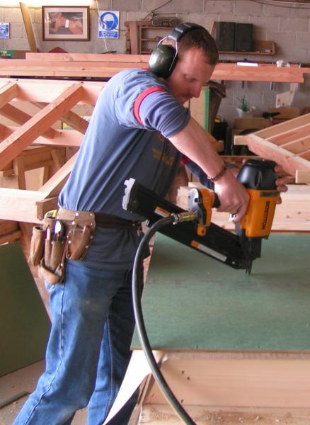 A man using a power saw to cut wall panels to size.