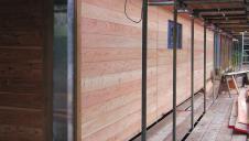 Larch cladding being fitted to the outside of a building during construction.