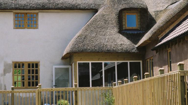Restored Devon cob farmhouse with thatched roof.
