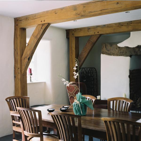 Exposed oak floor beams and braces in a dining room.