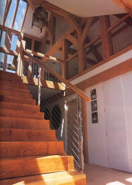 Spacious stairwell of a timber framed home with lantern above.