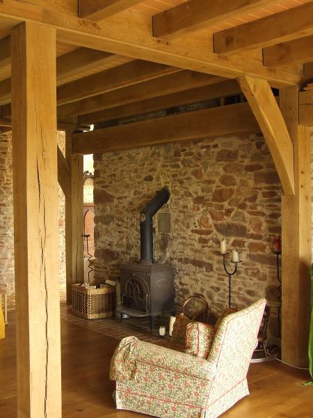 Traditional sitting room with log burning stove and oak beams.