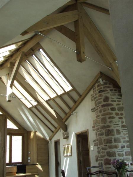 Direct glazed roof in an oak framed barn with exposed stone.