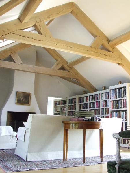 A room in the roof library with oak trusses.
