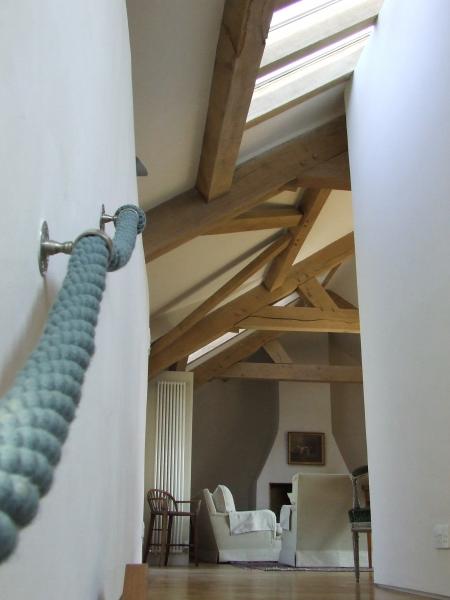 Rope bannister leading to an oak framed roof.