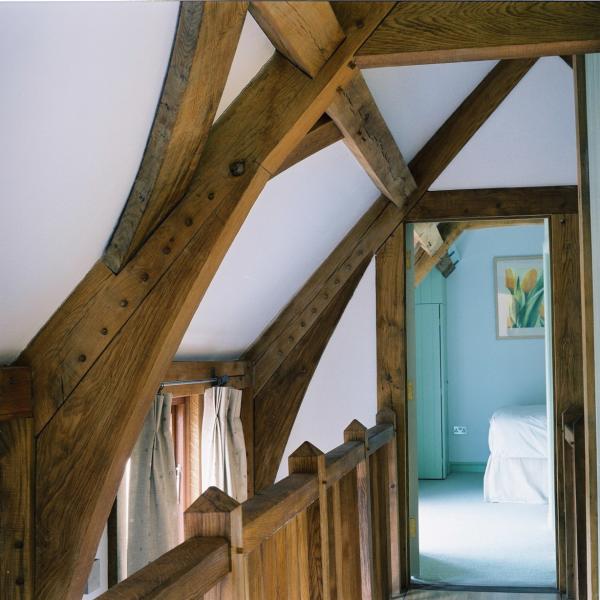 Oak roofing and oak bannisters in a corridor.