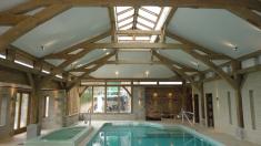 Oak framed swimming pool with sling brace trusses and a lantern.