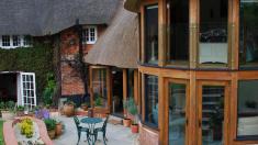 Round oak framed extension to a thatched listed building.