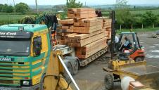 A lorry delivering timber to a framing yard.