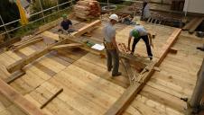 A Douglas fir cross frame being assembled on a scaffolding deck.