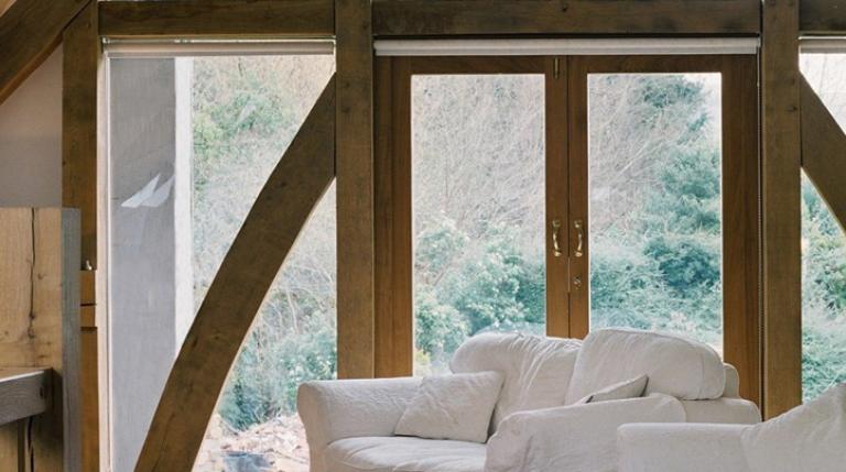Glazed oak gable frame with white sofas.