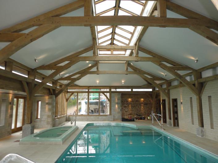 Pool house with oak sling brace trusses and lantern above.
