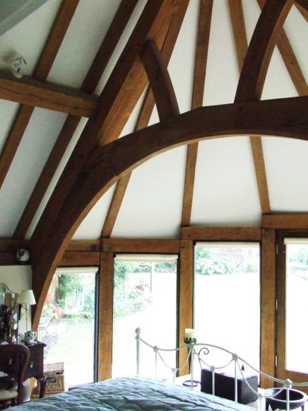 An oak framed bedroom with curved feature window.